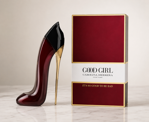Carolina Herrera Good Girl perfume bottle shaped like a stiletto high heel in deep burgundy with a black toe cap and gold heel, displayed next to its red and gold packaging box on a light marble surface.